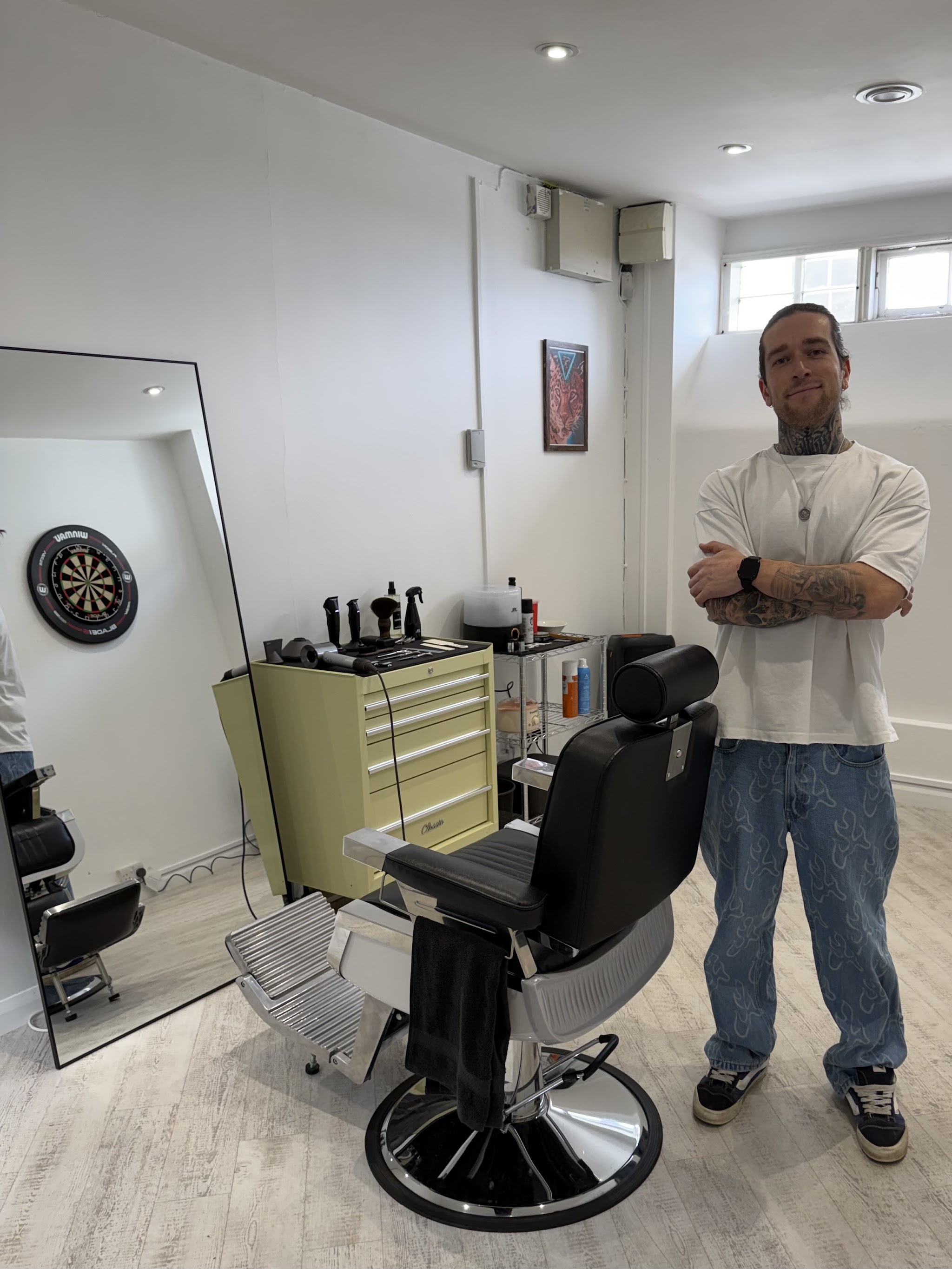 Marcus, arms folded, beside the barber chair in Appetite Barbershop